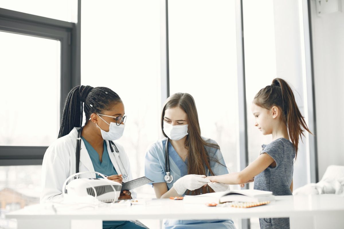 Medical Professionals Wearing Facemasks while Checking the Girl